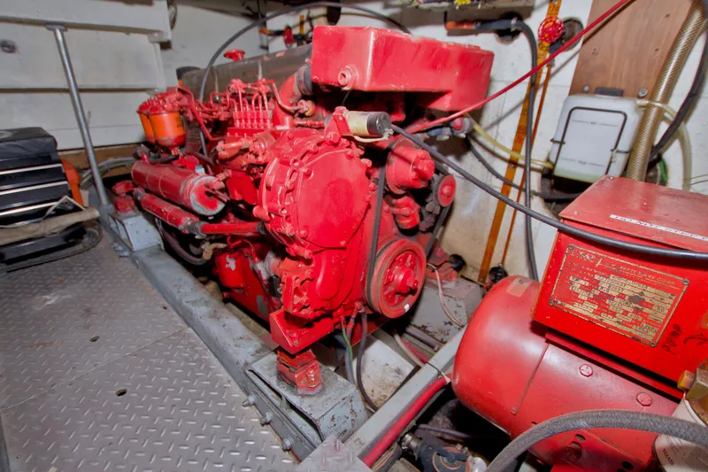 Slide: The Image of Engine room of a 1984 Present Yachts 42 Sundeck, featuring a red marine engine. - 71