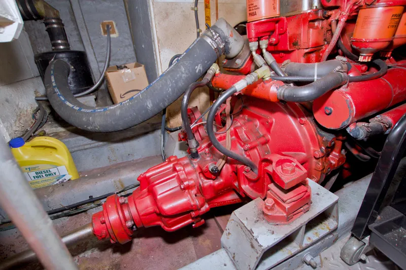 Slide: The Image of Engine room of 1984 Present Yachts 42 Sundeck with red machinery and hoses. - 74