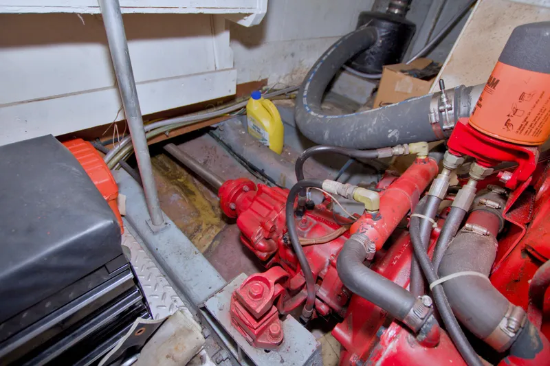 Slide: The Image of Engine room of 1984 Present Yachts 42 Sundeck, featuring red machinery and hoses. - 75