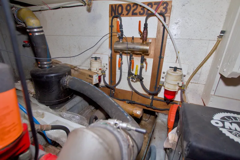 Slide: The Image of Engine room of 1984 Present Yachts 42 Sundeck, showcasing mechanical components and piping. - 77