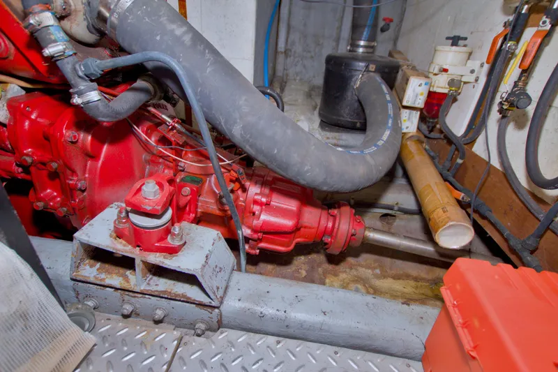 Slide: The Image of Engine room of 1984 Present Yachts 42 Sundeck, featuring red machinery and hoses. - 78