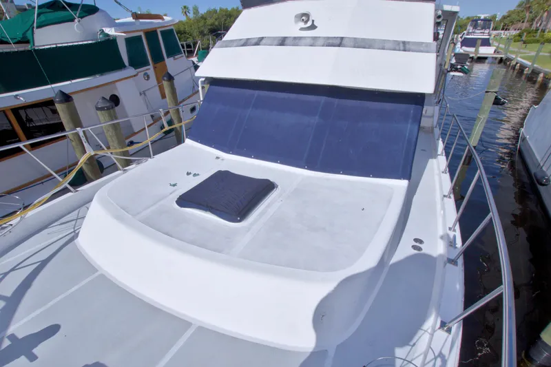 Slide: The Image of 1984 Present Yachts 42 Sundeck, docked, showcasing spacious deck and sleek design. - 8