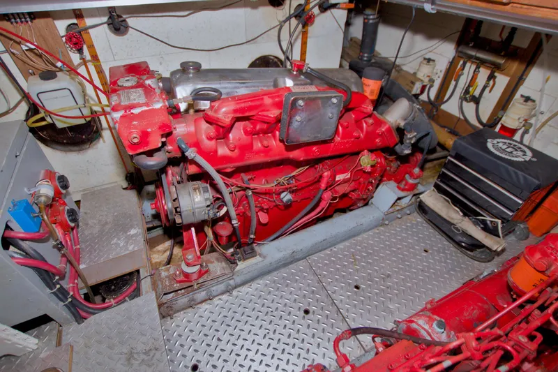 Slide: The Image of Engine room of a 1984 Present Yachts 42 Sundeck, featuring a red marine engine. - 80