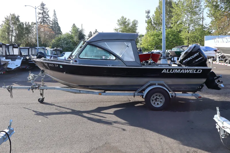 Slide: The Image of 1992 Alumaweld FV boat on trailer with Mercury outboard motor, parked outdoors. - 4