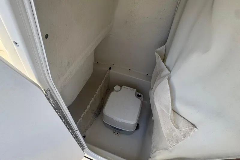 Slide: The Image of 2015 Key West 219 FS boat interior storage compartment with portable toilet. - 10