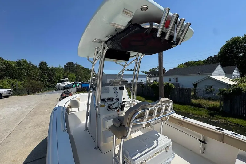 Slide: The Image of 2015 Key West 219 FS boat with T-top and console, parked outdoors on a sunny day. - 20