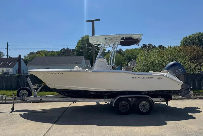 The Image of 2015 Key West 219 FS boat on trailer, parked outdoors in a residential area. - 6