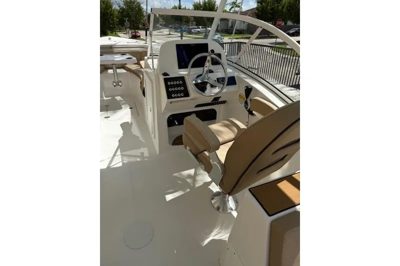 Slide: The Image of 2025 Sea Pro 240 Dual Console boat with covered engine, parked under a clear sky. - 10