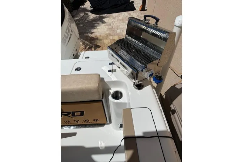 Slide: The Image of 2025 Sea Pro 240 Dual Console boat on trailer under clear blue sky. - 12