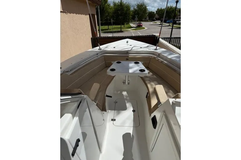 Slide: The Image of 2025 Sea Pro 240 Dual Console boat interior with beige seating and central table. - 15