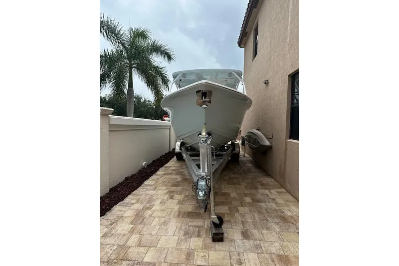 Slide: The Image of 2025 Sea Pro 240 Dual Console boat on trailer under clear blue sky. - 2