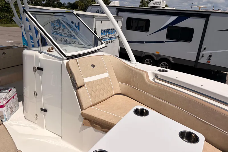 Slide: The Image of 2025 Sea Pro 240 Dual Console boat interior with beige seating and cup holders. - 23