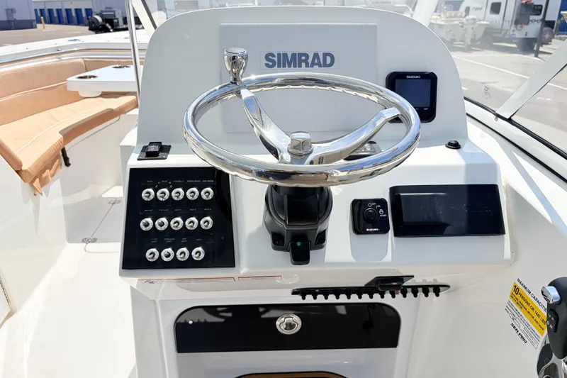Slide: The Image of 2025 Sea Pro 240 Dual Console boat dashboard with Simrad navigation system and controls. - 25