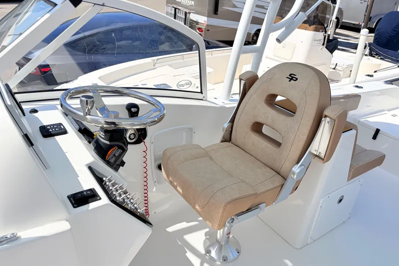 Slide: The Image of 2025 Sea Pro 240 Dual Console boat interior with steering wheel and captain's chair. - 26