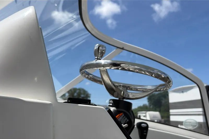 Slide: The Image of Steering wheel of 2025 Sea Pro 240 Dual Console boat under clear blue sky. - 27