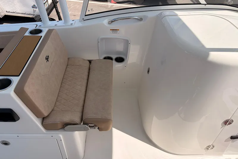 Slide: The Image of 2025 Sea Pro 240 Dual Console interior with beige seating and cup holders. - 30