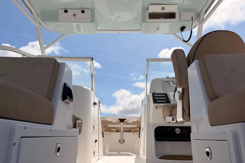 Slide: The Image of 2025 Sea Pro 240 Dual Console interior with seating and controls under blue sky. - 32