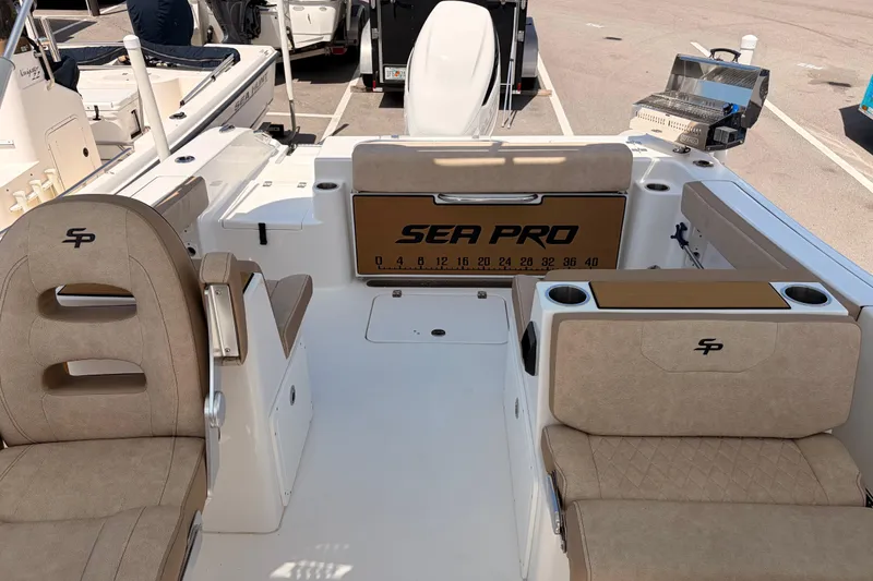 Slide: The Image of 2025 Sea Pro 240 Dual Console boat interior with beige seating and branded details. - 33