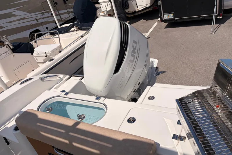 Slide: The Image of 2025 Sea Pro 240 Dual Console boat with Suzuki outboard motor in a marina setting. - 39