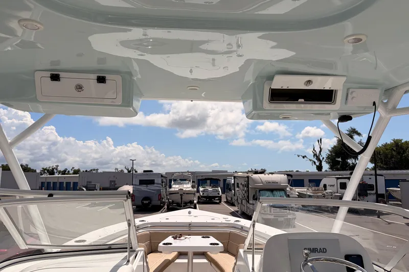 Slide: The Image of 2025 Sea Pro 240 Dual Console boat interior with clear sky and parked vehicles. - 41