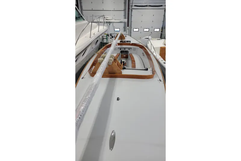 Slide: The Image of 2018 C.W. Hood 32 Daysailer in a garage, showcasing sleek deck design. - 10