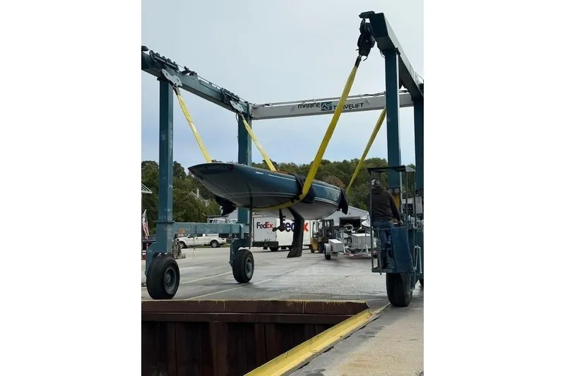 Slide: The Image of 2018 C.W. Hood 32 Daysailer being lifted by a marine travel lift at a dockyard. - 5