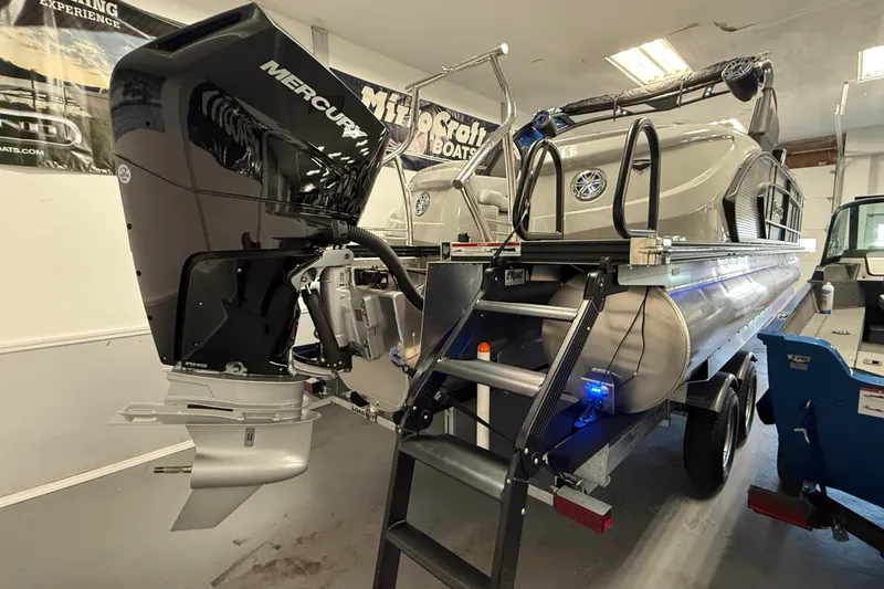 Slide: The Image of 2026 Manitou 25 LX RFW pontoon boat with Mercury engine in showroom. - 12