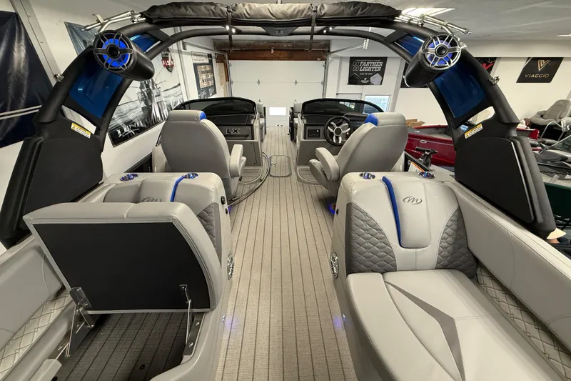 Slide: The Image of Luxurious interior of 2026 Manitou 25 LX RFW pontoon boat with modern seating and speakers. - 14