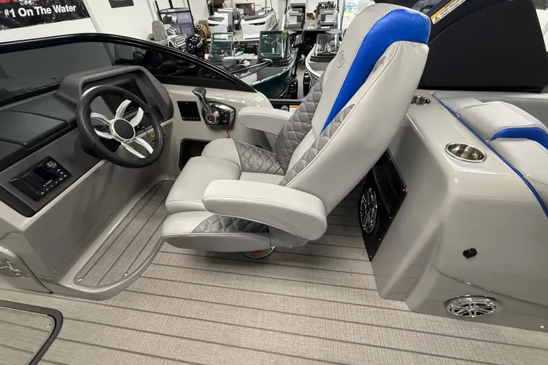 Slide: The Image of 2026 Manitou 25 LX RFW boat interior with modern steering and luxurious seating. - 4