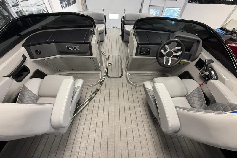 Slide: The Image of Interior of 2026 Manitou 25 LX RFW boat with modern seating and steering console. - 8