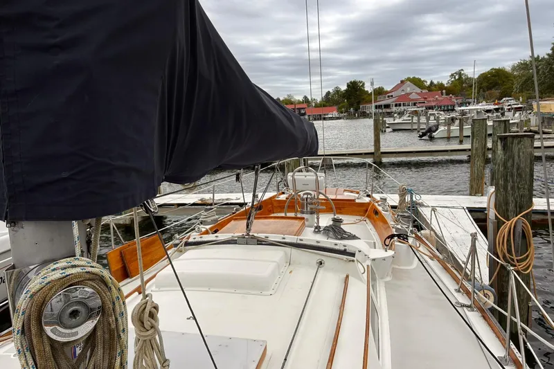 Slide: The Image of 1980 Hinckley Bermuda 40 MKIII sailboat docked at a marina under cloudy skies. - 12