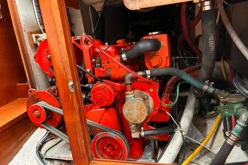 Slide: The Image of Engine compartment of a 1980 Hinckley Bermuda 40 MKIII sailboat, showcasing red mechanical components. - 14