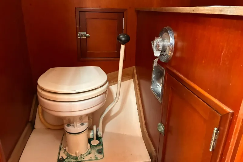 Slide: The Image of Hinckley Bermuda 40 MKIII 1980 yacht bathroom with marine toilet and wooden cabinetry. - 22