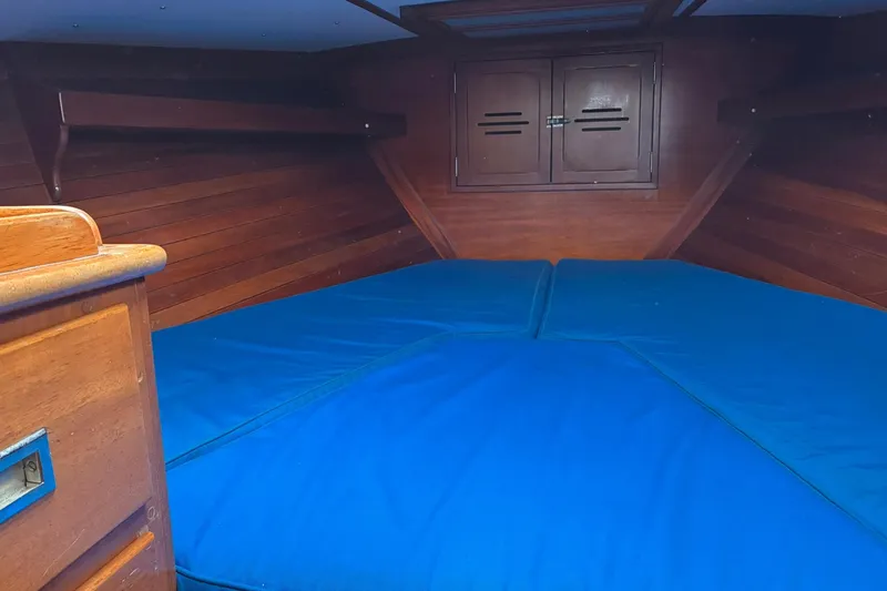 Slide: The Image of Interior cabin of 1980 Hinckley Bermuda 40 MKIII with blue cushions and wooden finish. - 26