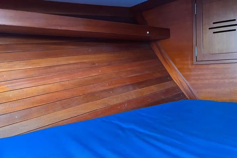 Slide: The Image of Interior of 1980 Hinckley Bermuda 40 MKIII with wooden paneling and blue bedding. - 30