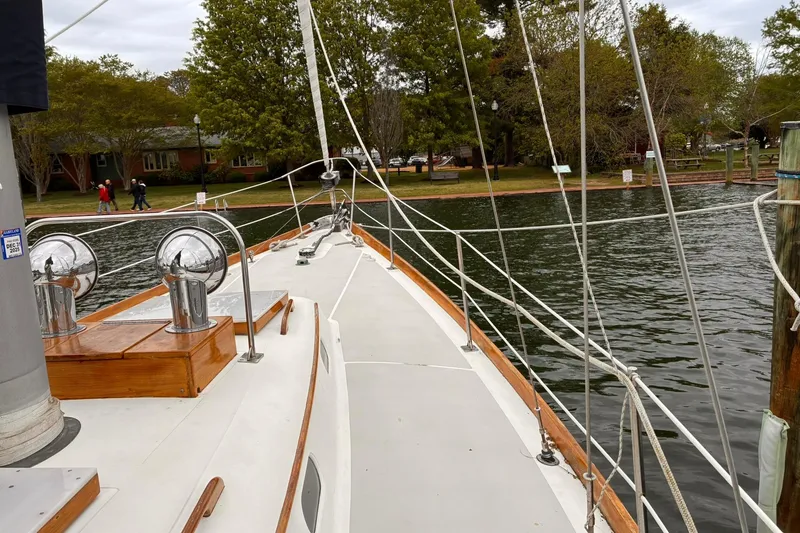Slide: The Image of 1980 Hinckley Bermuda 40 MKIII sailboat docked by a scenic waterfront. - 8