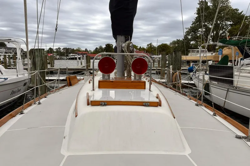 Slide: The Image of Hinckley Bermuda 40 MKIII sailboat deck, 1980 model, docked at a marina under cloudy skies. - 11