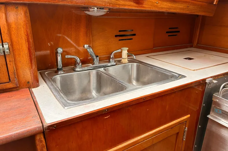 Slide: The Image of Galley sink area in 1980 Hinckley Bermuda 40 MKIII sailboat with wooden cabinetry. - 14