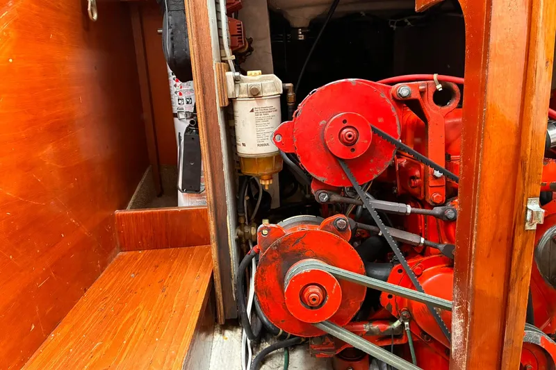 Slide: The Image of Engine compartment of 1980 Hinckley Bermuda 40 MKIII sailboat with red mechanical components. - 16