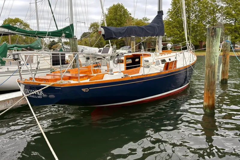 Slide: The Image of 1980 Hinckley Bermuda 40 MKIII sailboat docked in a marina, featuring classic design. - 2