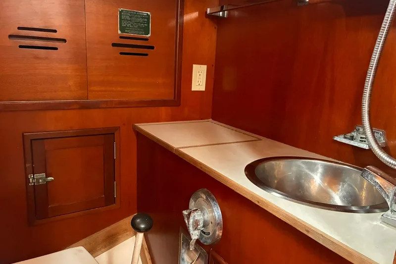 Slide: The Image of Interior of 1980 Hinckley Bermuda 40 MKIII yacht with wooden cabinetry and stainless steel sink. - 24