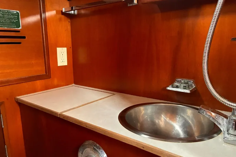 Slide: The Image of Hinckley Bermuda 40 MKIII 1980 yacht interior with wooden cabinetry and stainless steel sink. - 25