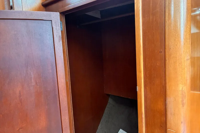 Slide: The Image of Wooden interior of 1980 Hinckley Bermuda 40 MKIII sailboat, featuring an open storage compartment. - 26