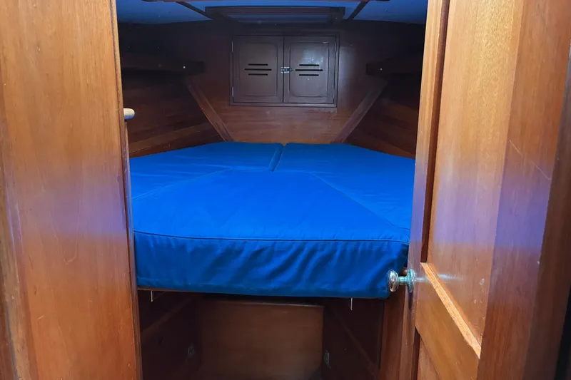 Slide: The Image of Interior cabin of 1980 Hinckley Bermuda 40 MKIII with blue bedding and wooden finish. - 28