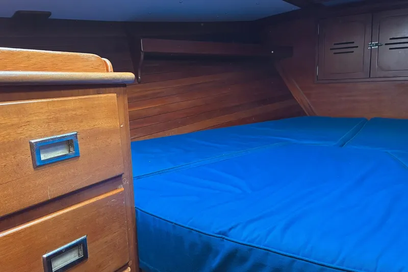 Slide: The Image of Interior cabin of 1980 Hinckley Bermuda 40 MKIII with blue bedding and wooden cabinetry. - 32