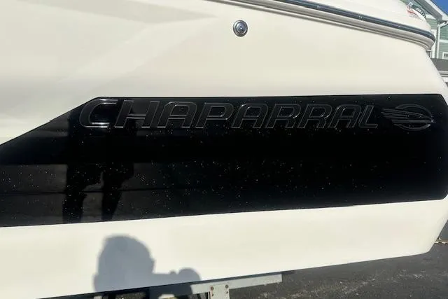Slide: The Image of 2026 Chaparral 247 SSX boat with sleek black branding on the side. - 2