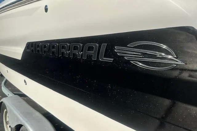 Slide: The Image of 2026 Chaparral 247 SSX boat logo on sleek black and white hull. - 3
