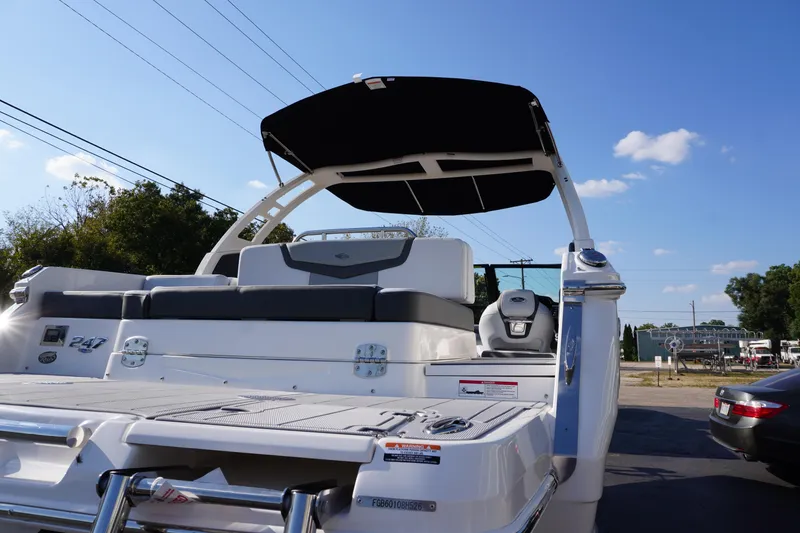 Slide: The Image of 2026 Chaparral 247 SSX boat with sleek design and black canopy under clear blue sky. - 6