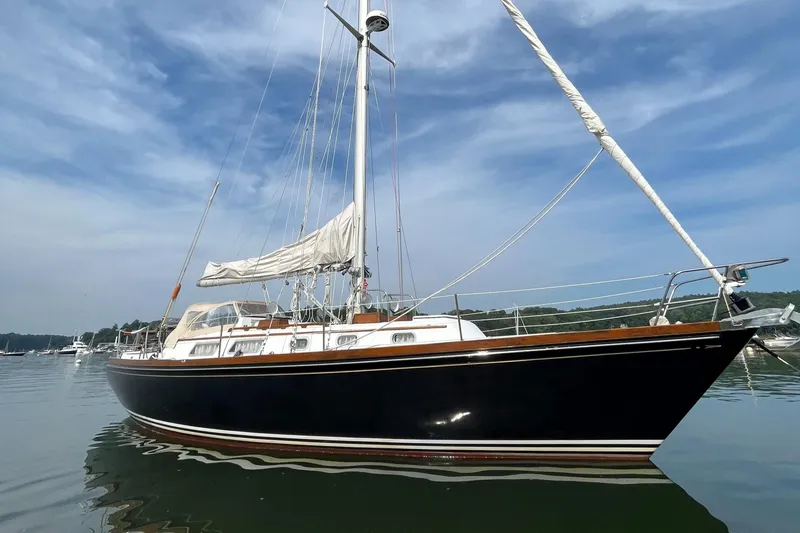 The Image of 1982 Bristol 38.8 sailboat on calm water under blue sky. - 0