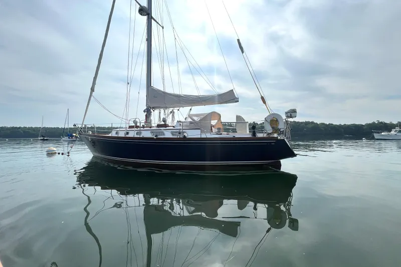 Slide: The Image of 1982 Bristol 38.8 sailboat on calm water under cloudy sky. - 12